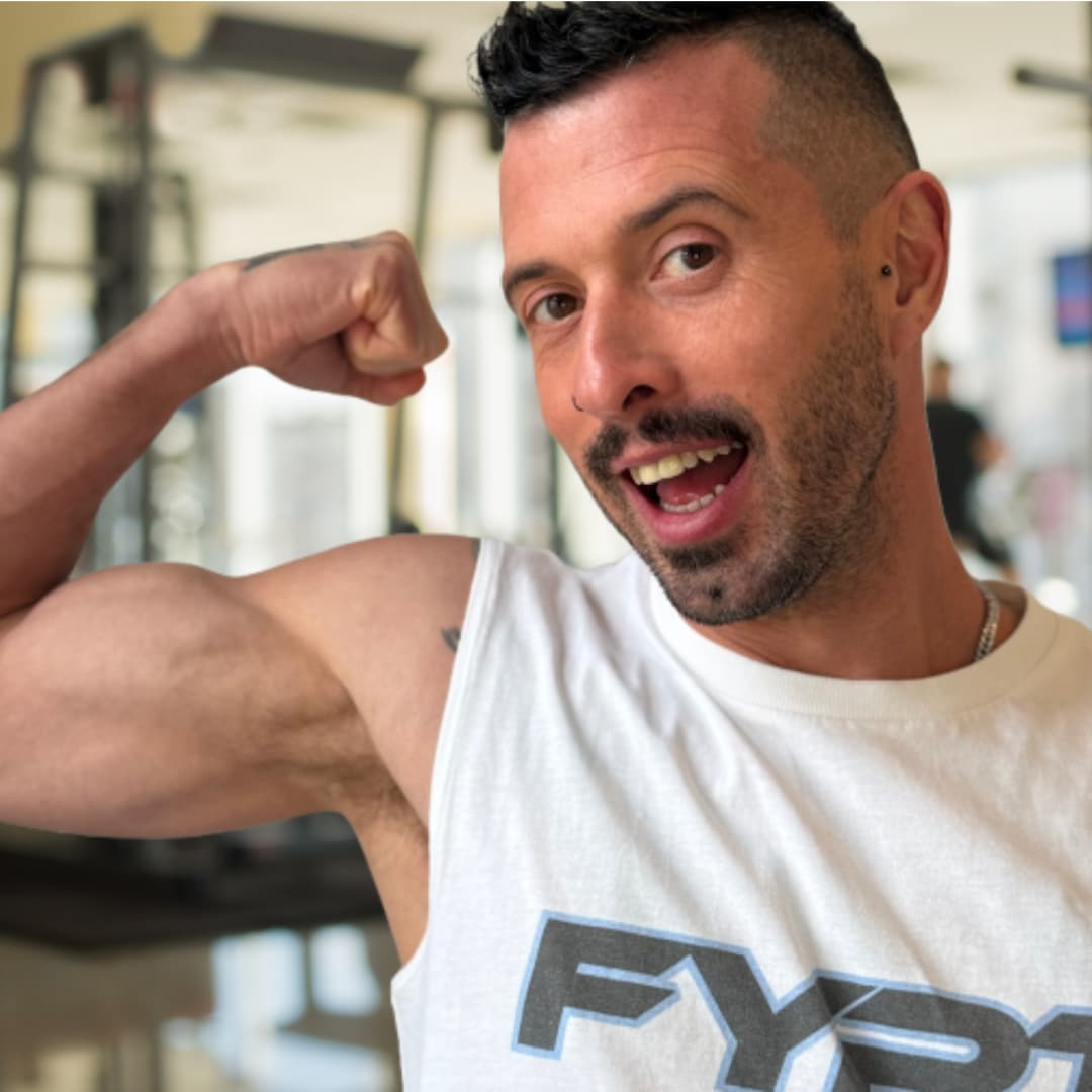 Dave Price, founder of Future You PT poses with a flexed bicep